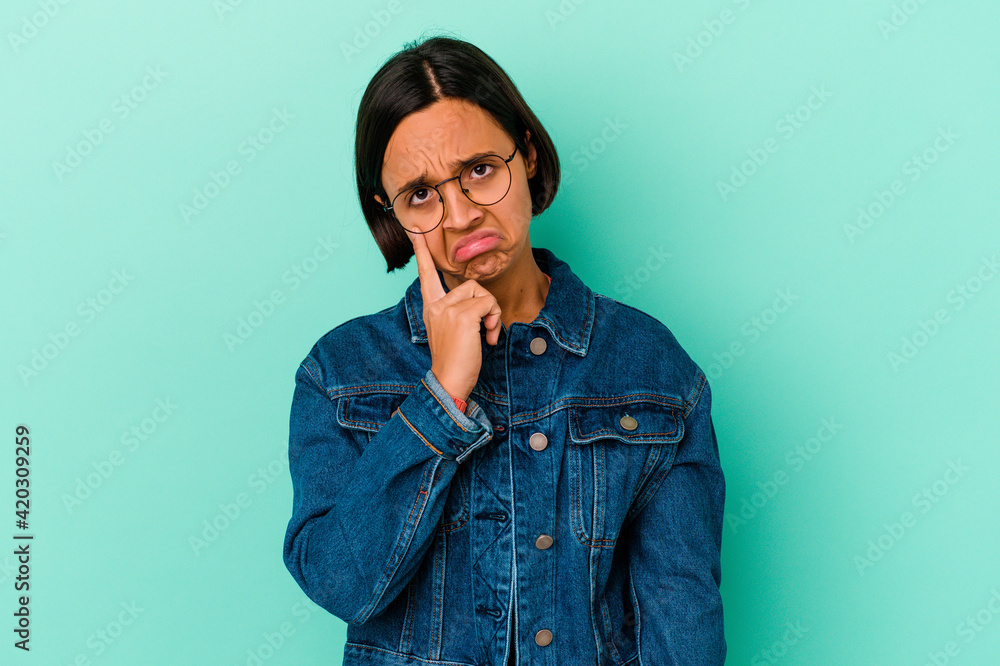 Young mixed race woman isolated on blue background crying, unhappy with something, agony and confusion concept. Young mixed race woman isolated on blue background crying, unhappy with something, agony and confusion concept.