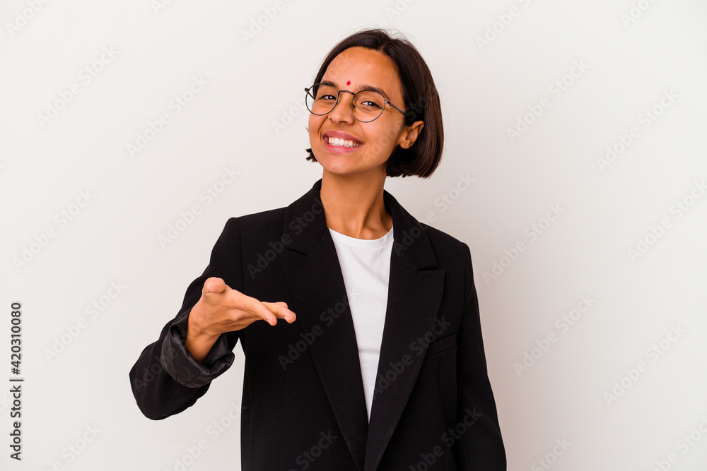 Young business Indian woman isolated on white background stretching hand at camera in greeting gesture. Young business Indian woman isolated on white background stretching hand at camera in greeting gesture.