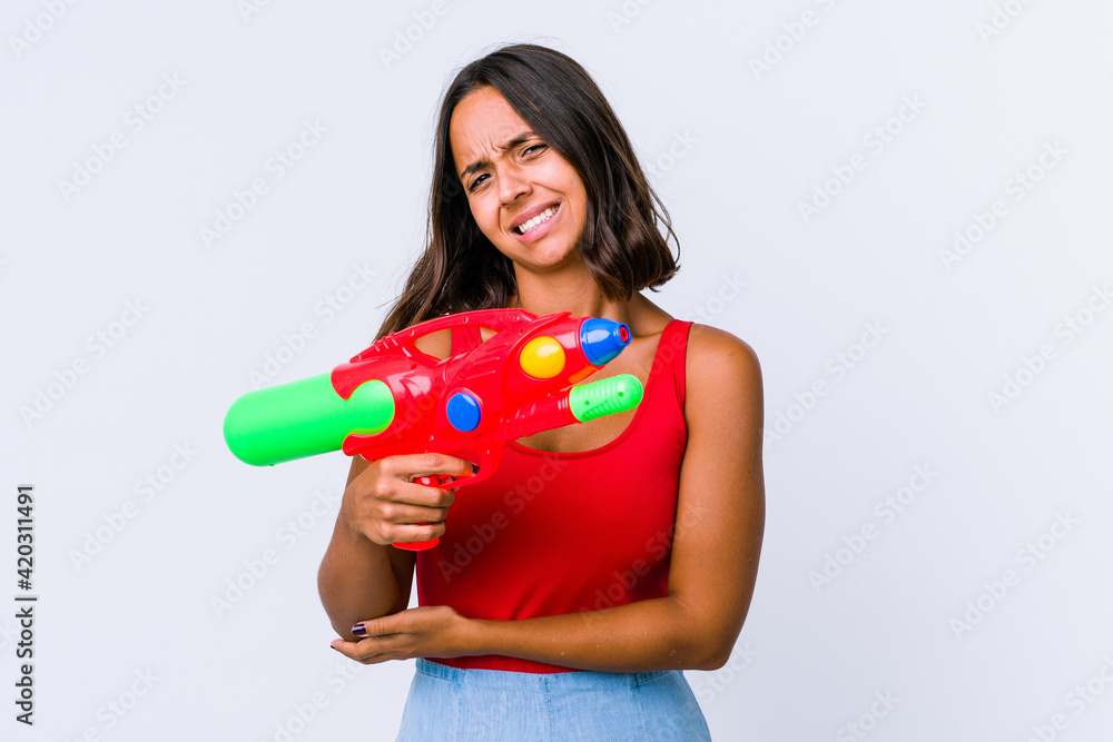 Young mixed race woman holding a water gun isolated massaging elbow, suffering after a bad movement. Young mixed race woman holding a water gun isolated massaging elbow, suffering after a bad movement.