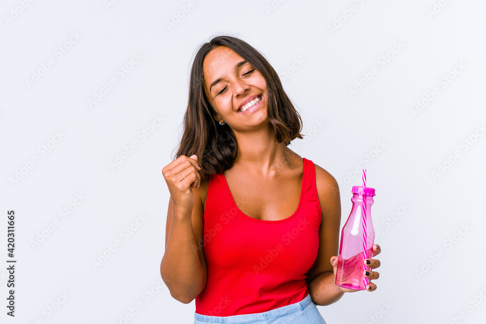 Young mixed race woman holding a milk shake isolated celebrating a victory, passion and enthusiasm, happy expression. Young mixed race woman holding a milk shake isolated celebrating a victory, passion and enthusiasm, happy expression.