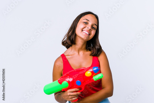 Young mixed race woman holding a water gun isolated who feels confident  crossing arms with determination.