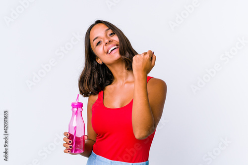 Young mixed race woman holding a milk shake isolated cheering carefree and excited. Victory concept.