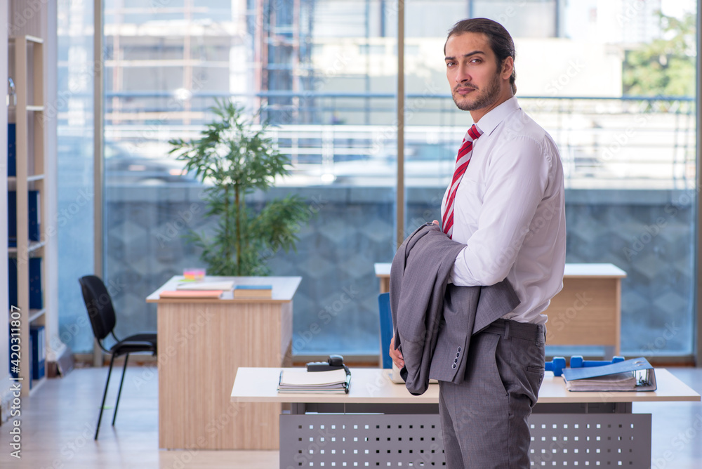 Young male employee doing sport exercises in the office Young male employee doing sport exercises in the office