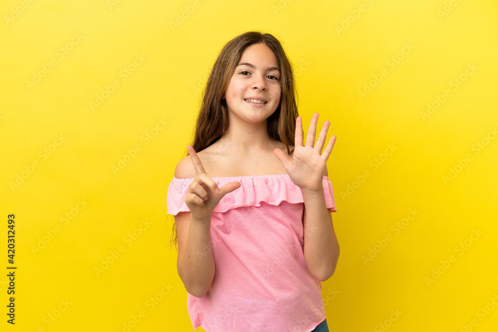 Little caucasian girl isolated on yellow background counting seven with fingers Little caucasian girl isolated on yellow background counting seven with fingers