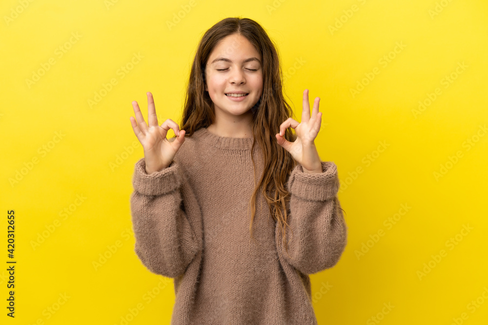 Little caucasian girl isolated on yellow background in zen pose Little caucasian girl isolated on yellow background in zen pose