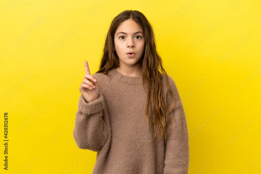 Little caucasian girl isolated on yellow background intending to realizes the solution while lifting a finger up Little caucasian girl isolated on yellow background intending to realizes the solution while lifting a finger up