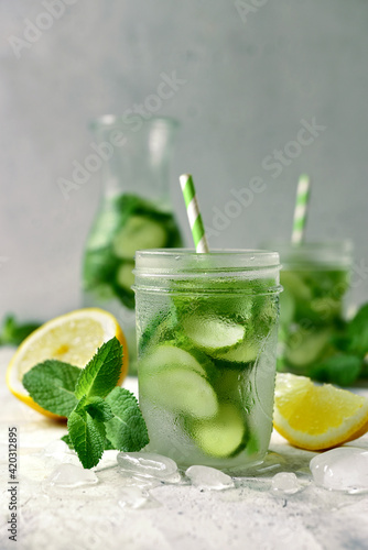 Delicious cold summer lemonade with cucumber and mint in a mason jars.