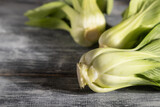 Fresh green bok choy or pac choi chinese cabbage on a gray wooden background. Side view, copy space, selective focus.