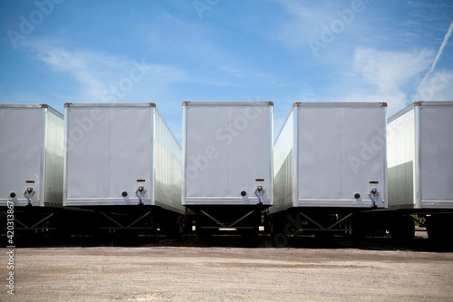 Row of transport truck trailers in a yard photo
