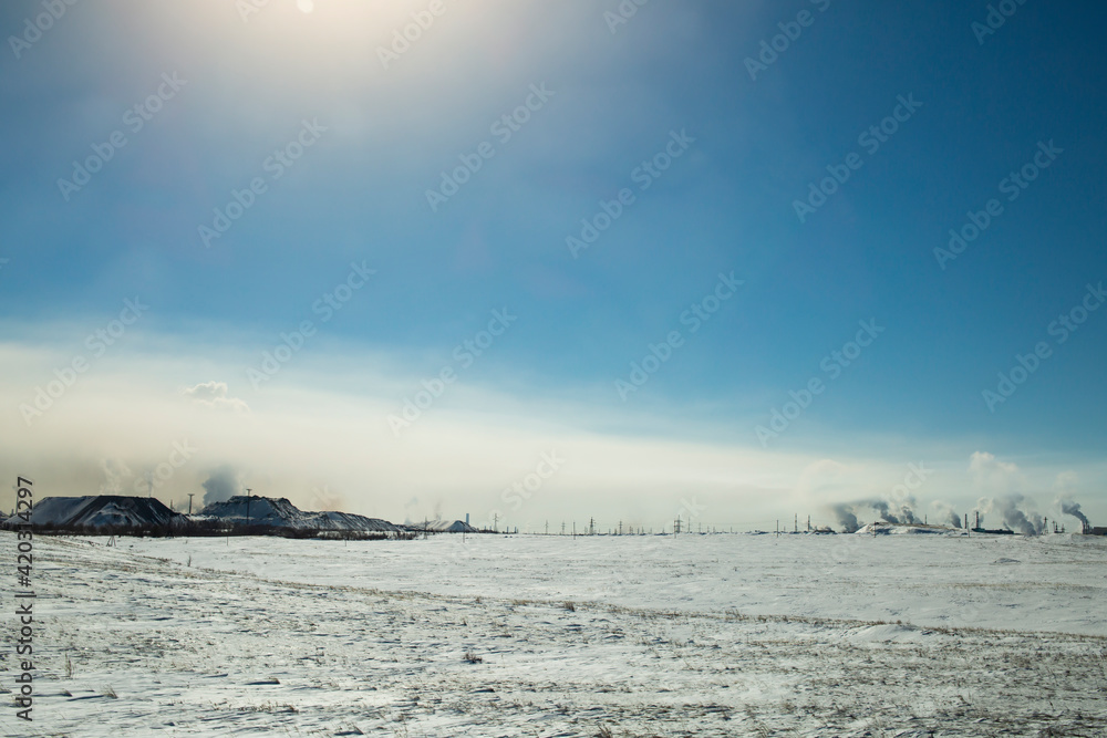 Fog, smoke from chemical production spreads over the ground on a sunny winter day Fog, smoke from chemical production spreads over the ground on a sunny winter day