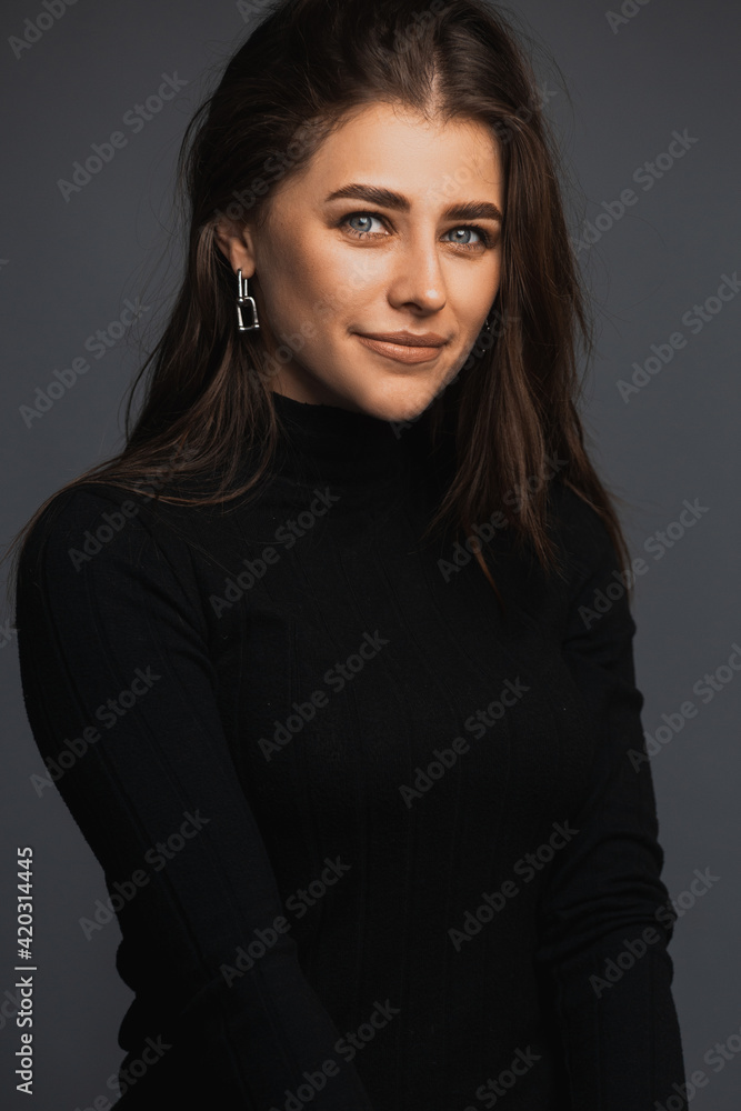 Portrait of a beauty young brunette wearing black turtleneck. Studio portrait