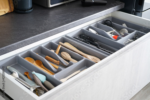 Set of clean kitchen utensils in drawer.