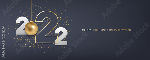 Happy new year 2022. White paper numbers and golden Christmas ball with confetti on dark blue background. Holiday greeting card design.