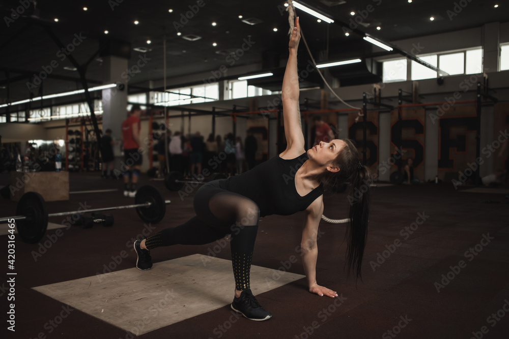 Fototapeta premium Female athlete stretching at functional training gym