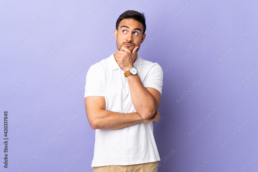 Young handsome man isolated on purple background thinking an idea while looking up Young handsome man isolated on purple background thinking an idea while looking up