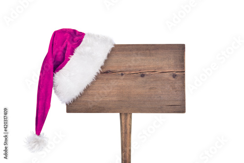 Winter Christmas Background with Wooden Signpost. Wooden road sign with Santa hat isolated on black background. Concept of New Year celebration. Merry Christmas