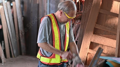 Elderly Asian carpenter working in the carpenter workshop.