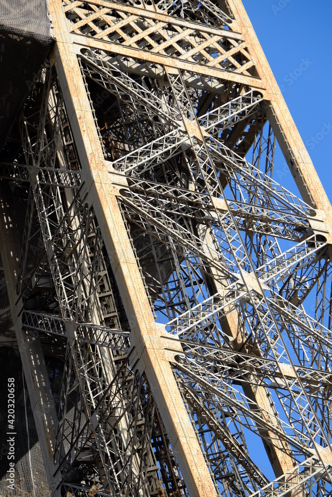 A close up on the Eiffel Tower during a sunny day during its renovation (stripping and painting). Paris the 14th march 2021