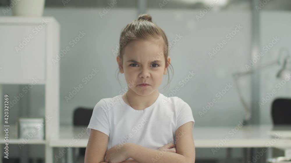 Close-up of a little girl who grimaces and sighs with a displeased expression, slowmotion. Close-up of a little girl who grimaces and sighs with a displeased expression, slowmotion.