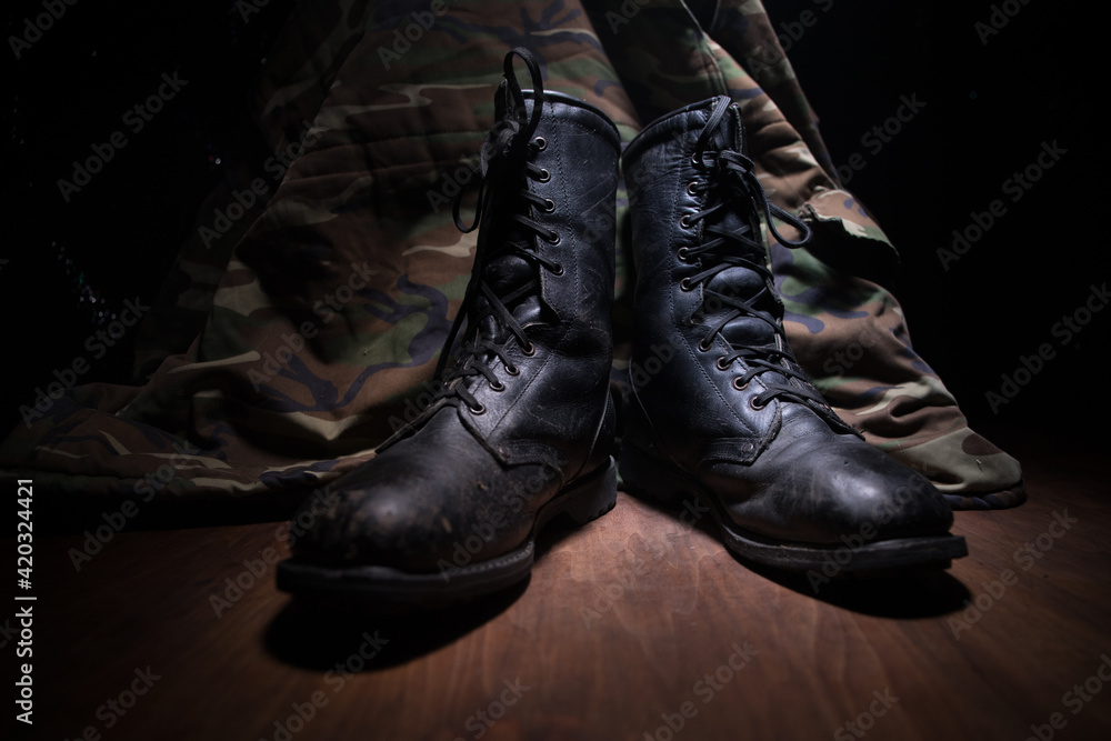 War concept. Old military shoe in a dark toned foggy background. Creative concept of conflict between countries, military aggression.