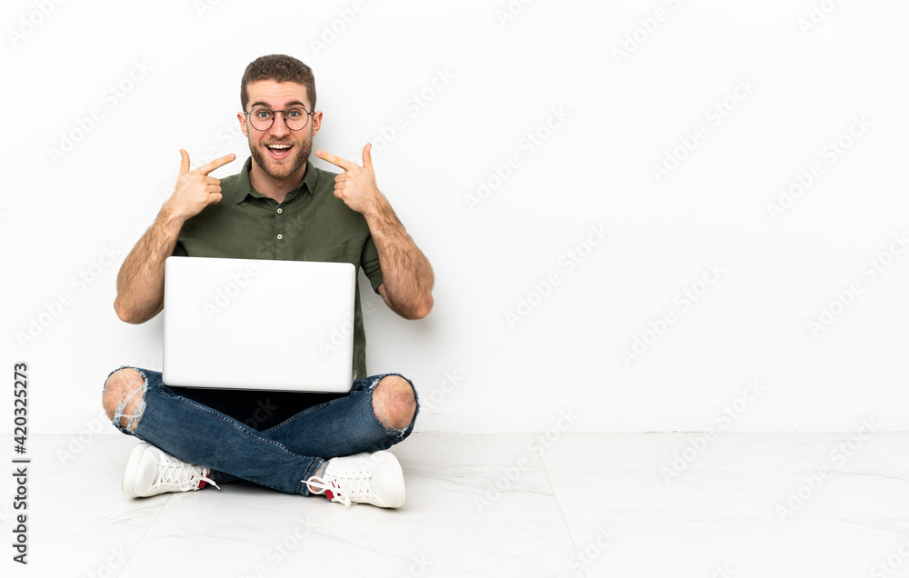 Young man sitting on the floor giving a thumbs up gesture Young man sitting on the floor giving a thumbs up gesture