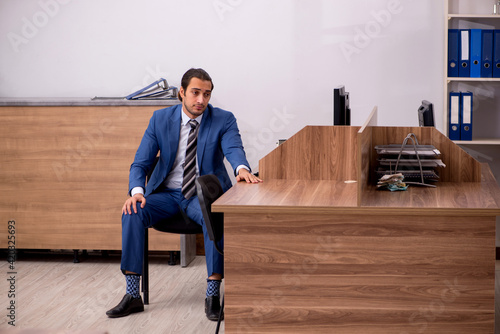 Young male employee sitting at workplace