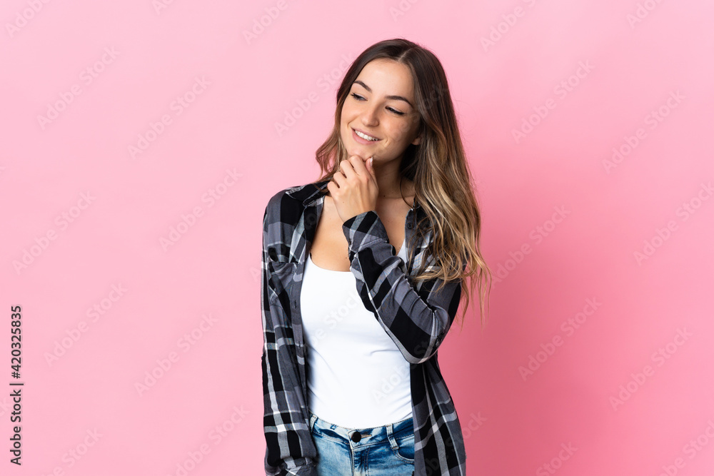 Young Romanian woman isolated on pink background looking to the side and smiling Young Romanian woman isolated on pink background looking to the side and smiling