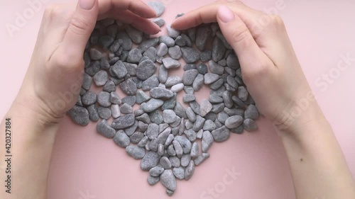 Woman hands creating heart from stones. SPA, manicure. Health concept. Close up.