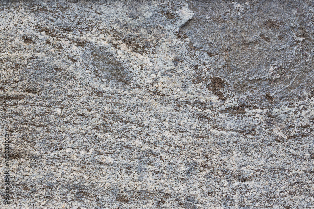 Granite texture. Natural gray granite with a grainy pattern. Stone background. Solid rough surface of rock. Durable construction and decoration material. Close-up. Granite texture. Natural gray granite with a grainy pattern. Stone background. Solid rough surface of rock. Durable construction and decoration material. Close-up.