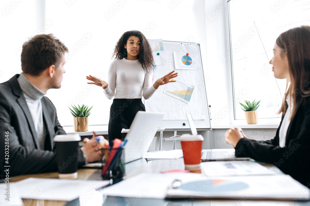 Serious female boss of company making a presentation about company profit to employees. Stylish influential young businesswoman talking about financial reports on briefing meeting, conference concept Serious female boss of company making a presentation about company profit to employees. Stylish influential young businesswoman talking about financial reports on briefing meeting, conference concept