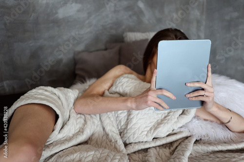 woman reading tablet in bed