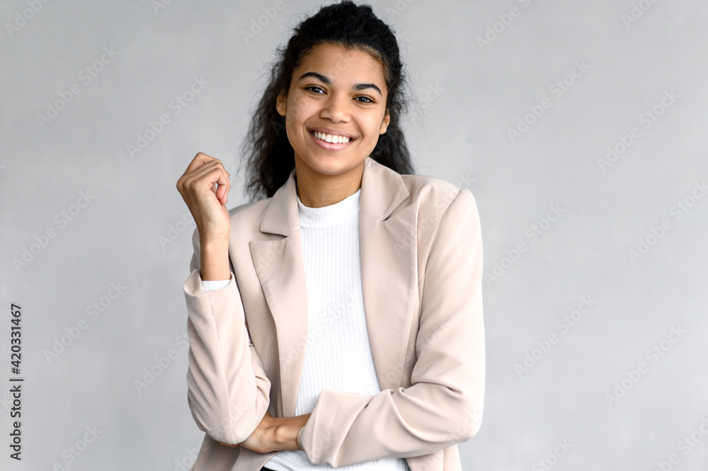 Portrait of elegant happy business woman or student in stylish formal suit. Beautiful young female is standing on isolated background, looking directly at the camera, smiling - obrazy, fototapety, plakaty 