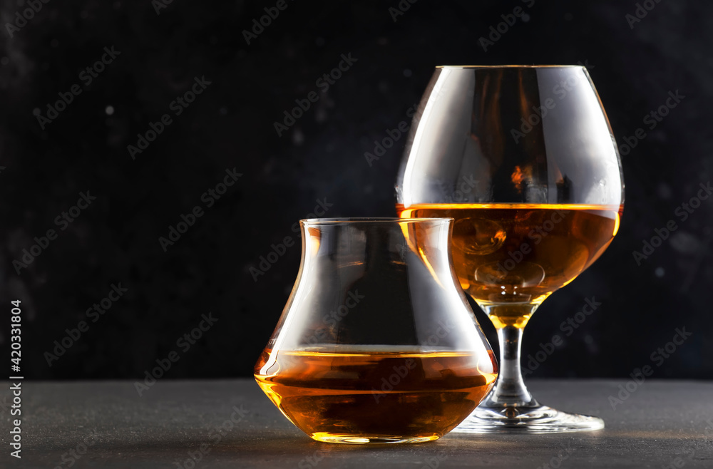 Cognac and scotch wisky in glasses, dark background, selective focus Cognac and scotch wisky in glasses, dark background, selective focus