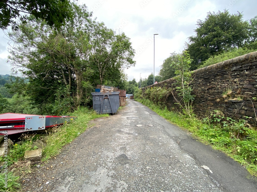 View of, skips and scrap metal, on a side road, next to, Manchester Road, Marsden, UK View of, skips and scrap metal, on a side road, next to, Manchester Road, Marsden, UK
