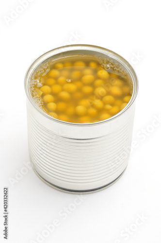 Metal tin can with green peas on a white background