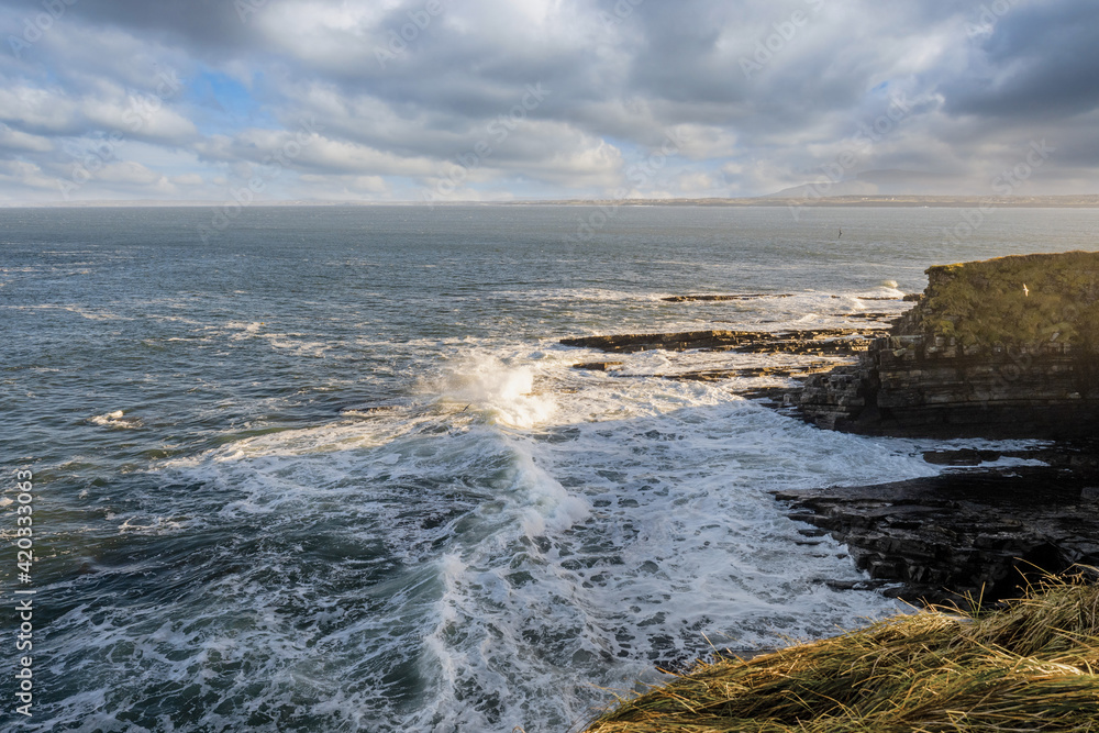 View on the Atlantic ocean. Mullaghmore peninsula, county Sligo, Ireland. Blue water with waves, cloudy sky, nobody.