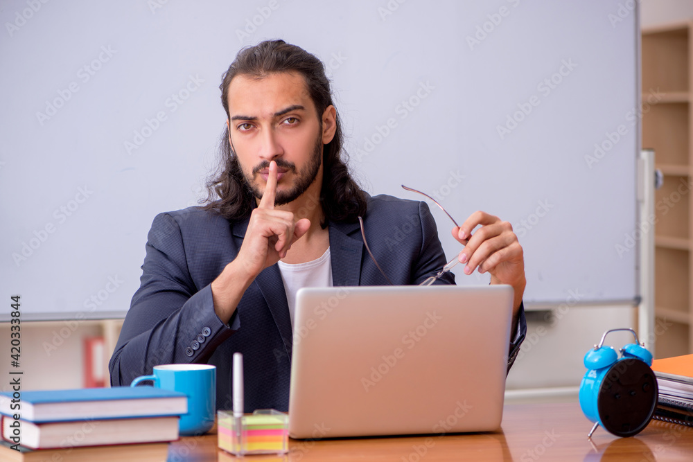 Young male teacher in the classroom Young male teacher in the classroom