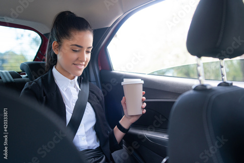 Businesswoman using laptop in car. © Mego-studio