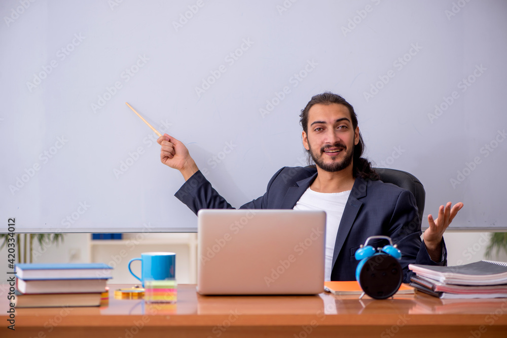 Young male teacher in the classroom Young male teacher in the classroom