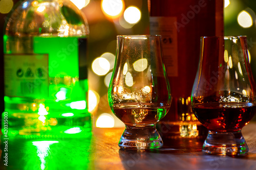 Glasses of scotch whisky served in bar in Edinburgh, Scotland, UK and pasry lights on background