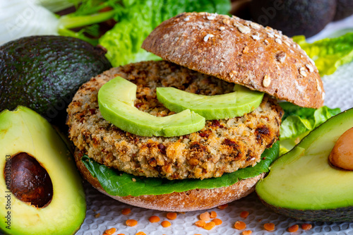 Fototapeta Naklejka Na Ścianę i Meble -  Tasty vegetarian healthy food, homemade burgers made from orange lentils legumes with green lettuce and fresh ripe avocado