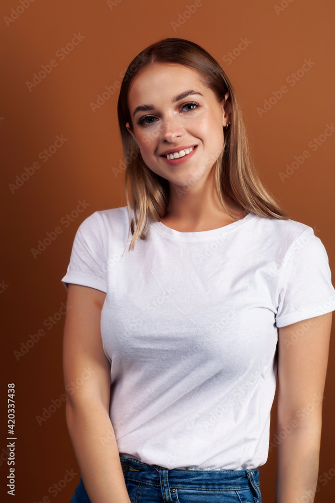 young pretty girl with blond hair posing cheerful on brown background, lifestyle people concept young pretty girl with blond hair posing cheerful on brown background, lifestyle people concept
