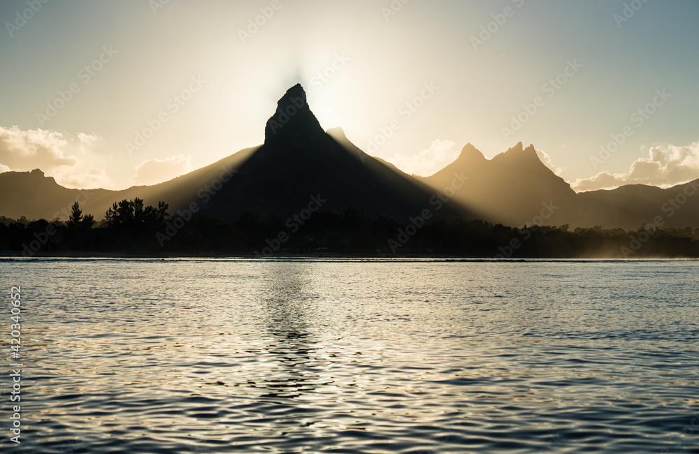 Sonnenaufgang hinter den Bergen im Süden von Mauritius. Fotografiert vom Motorboot aus.