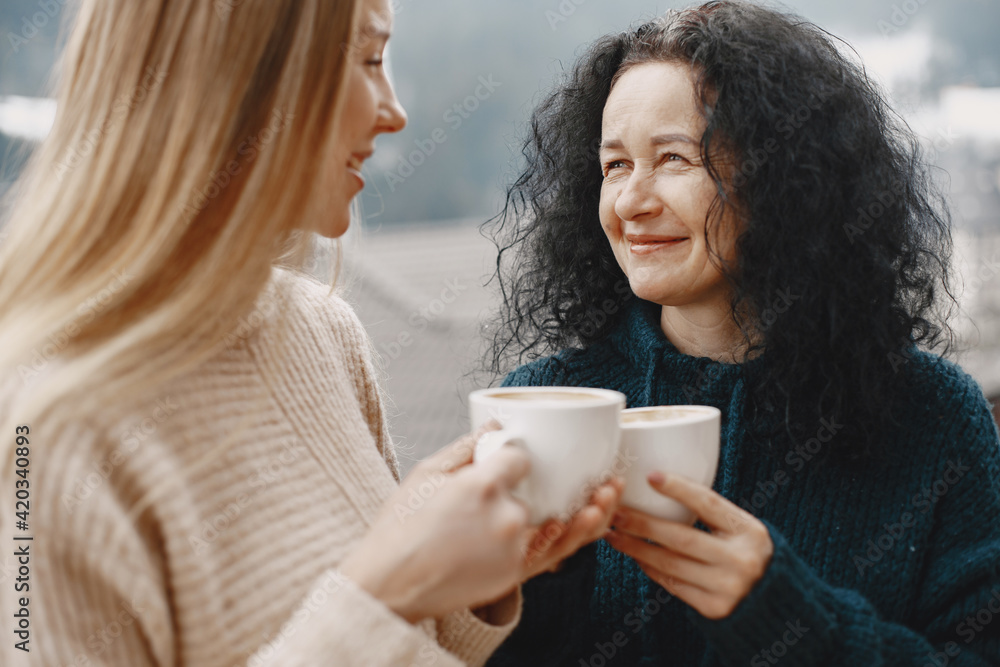 Women with a cup of coffee. Wonderful holiday in mountains. Snowy weather.