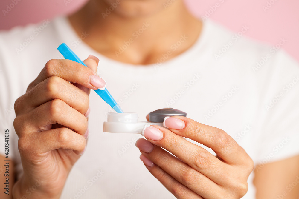 Young woman putting eye contact lens on her eyes Young woman putting eye contact lens on her eyes