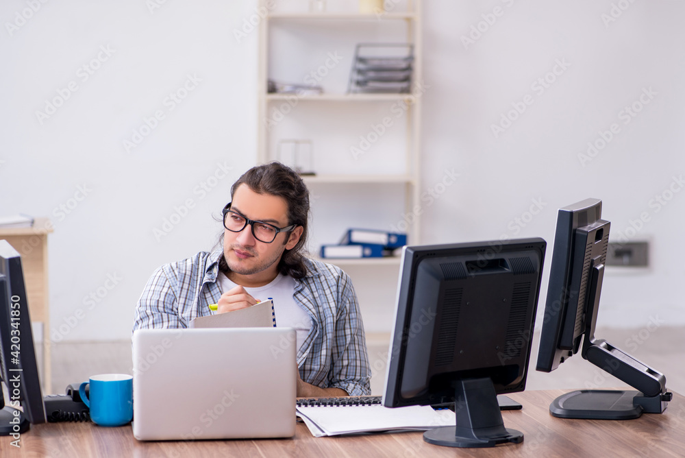 Young male it specialist working in the office Young male it specialist working in the office