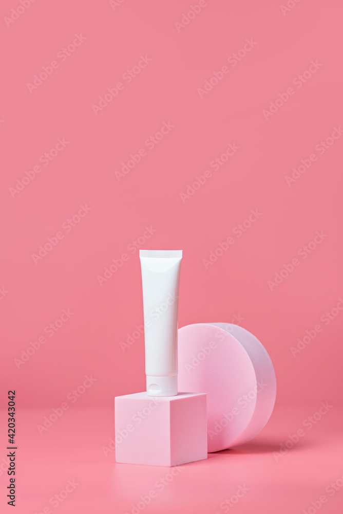 White tube on an light pink podiums. White blank unbranded flacons with cosmetology products. Professional concept of skin care White tube on an light pink podiums. White blank unbranded flacons with cosmetology products. Professional concept of skin care