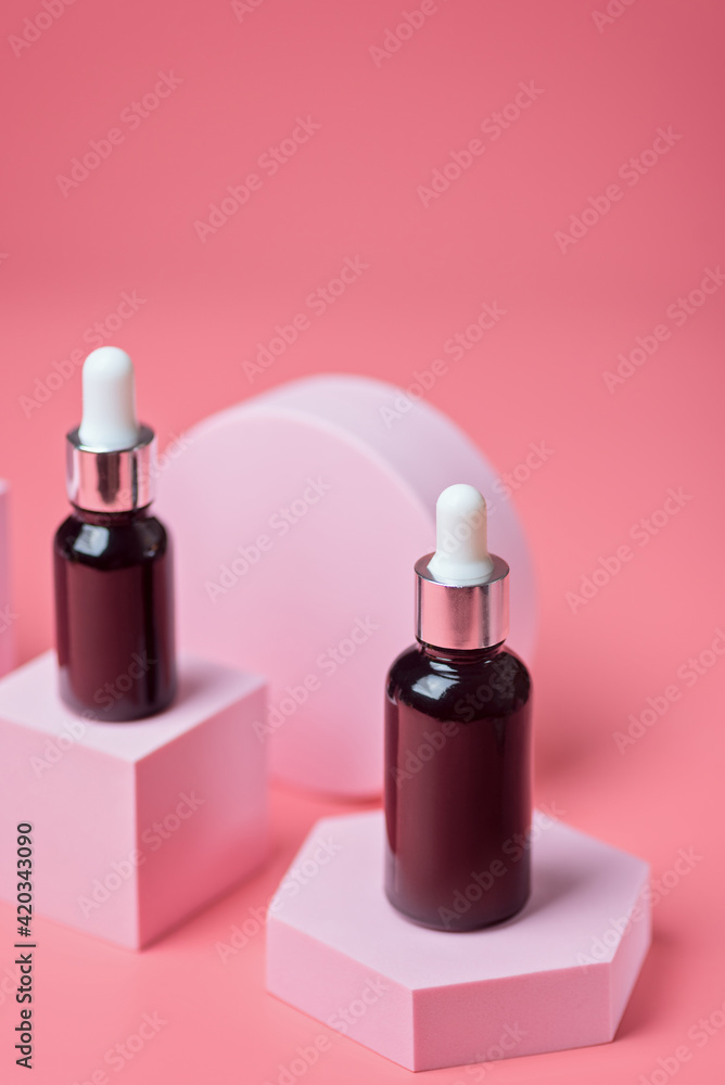 Serum in brown glass bottles with a pipette on a light pink background on pink podiums, mockup Serum in brown glass bottles with a pipette on a light pink background on pink podiums, mockup