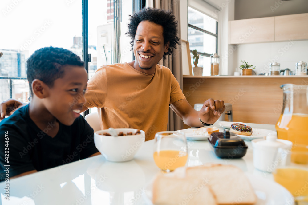 Father and son having breakfast together at home. Father and son having breakfast together at home.