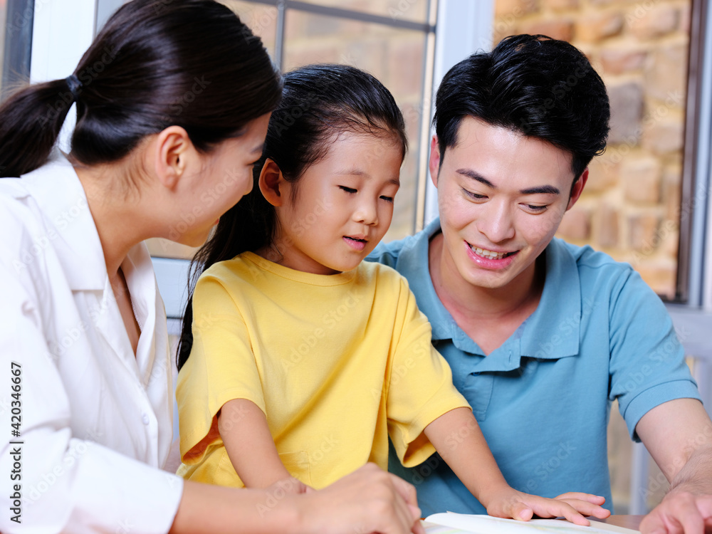 Happy family of three reading together Happy family of three reading together